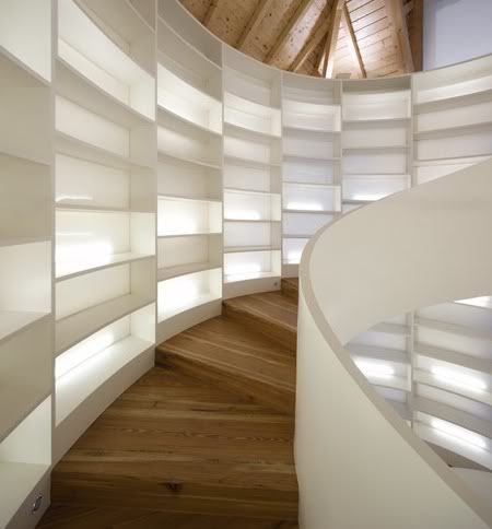white bookshelf lined spiral stairs